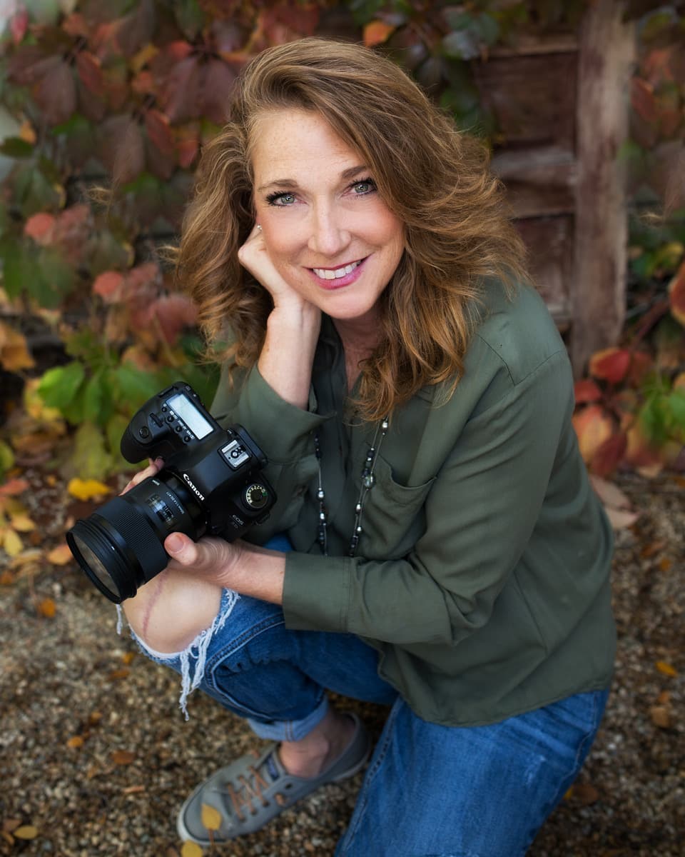 Robin Charlesworth, of BB Photography, smiling and holding a camera