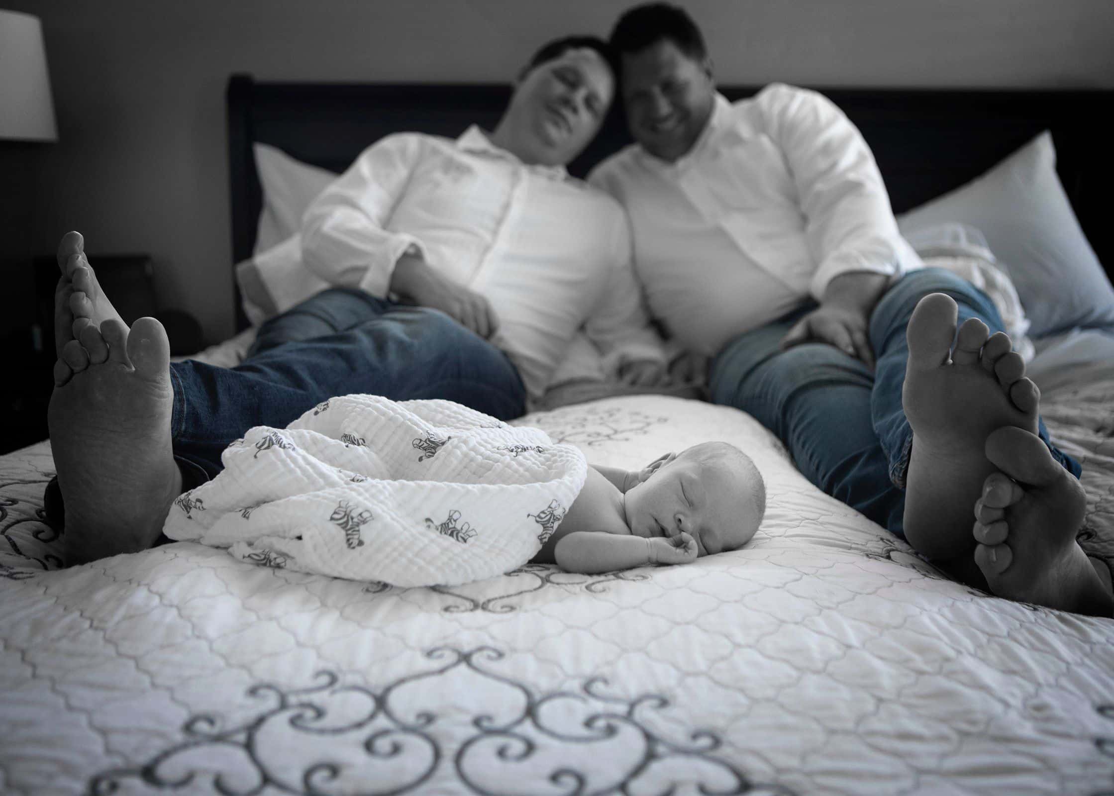 parents posing for photo with newborn