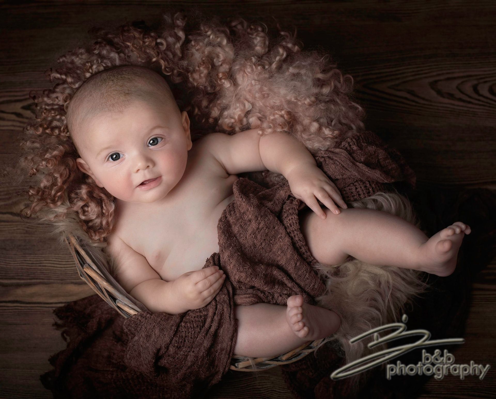 Baby in a basket with a brown blanket