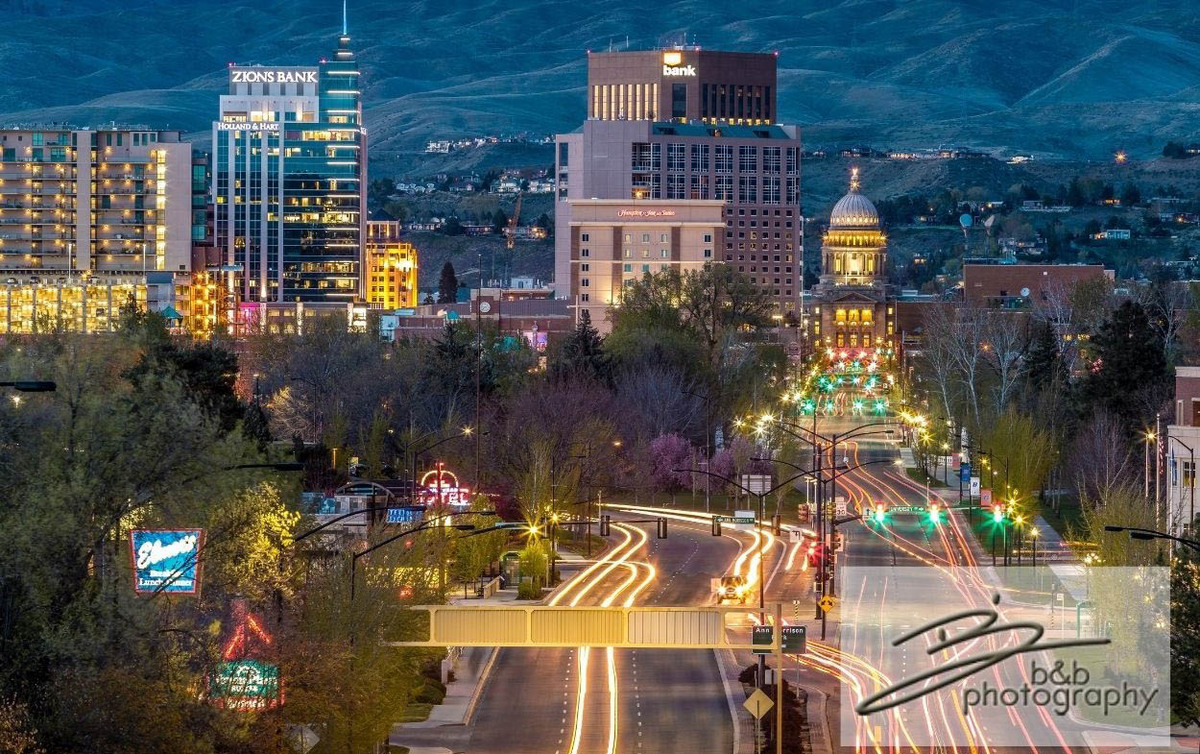Downtown Boise at night with cars driving and mountains in the background